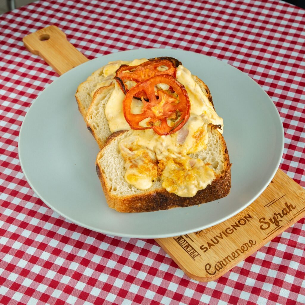 A delicious open-faced egg and tomato toast served on a checkered tablecloth, perfect for breakfast or brunch.